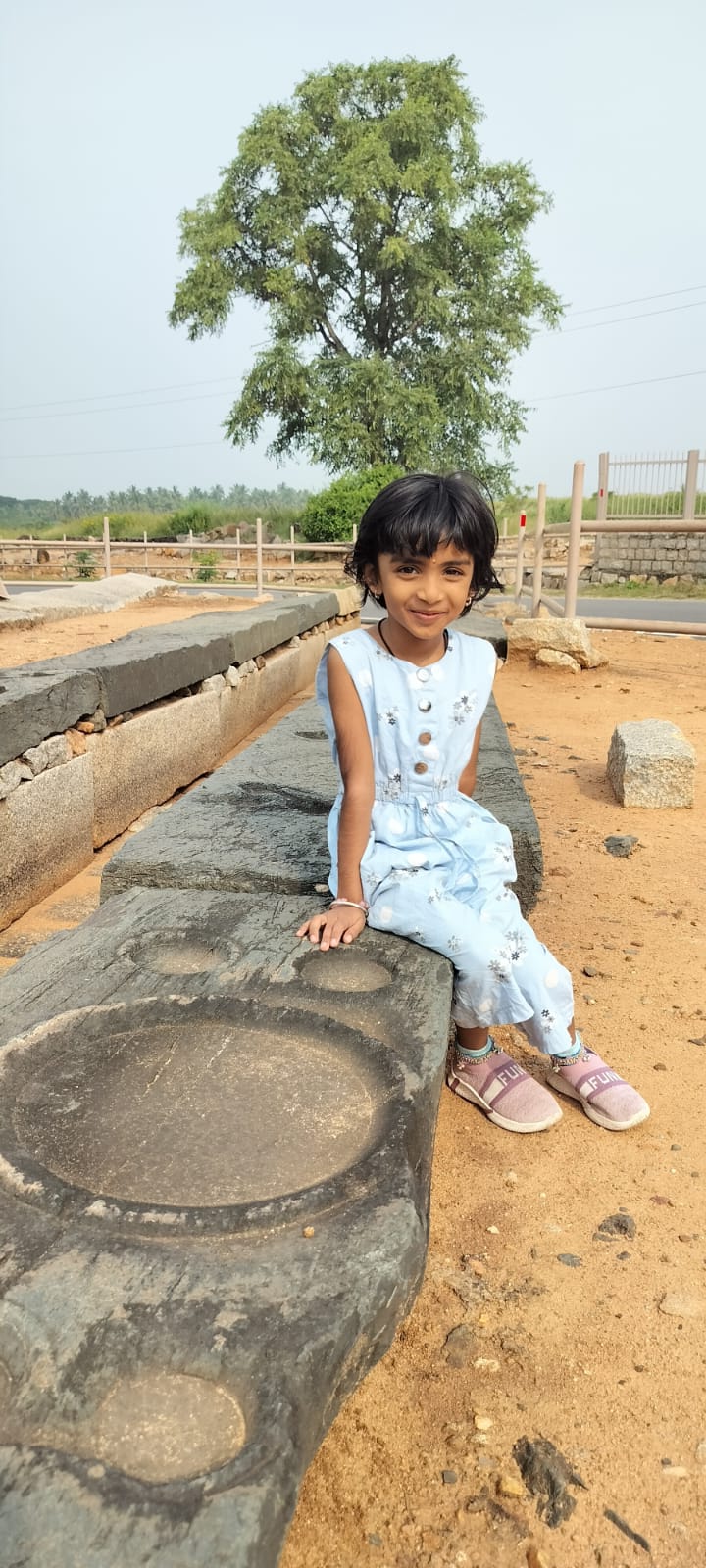 Traveller exploring boulder ruins in Hampi